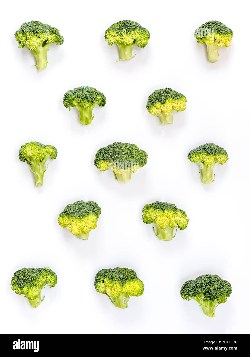 Immagine di un gruppo di broccoli grezzi posto su a. sfondo di cartone bianco e catturato dall'alto Foto Stock