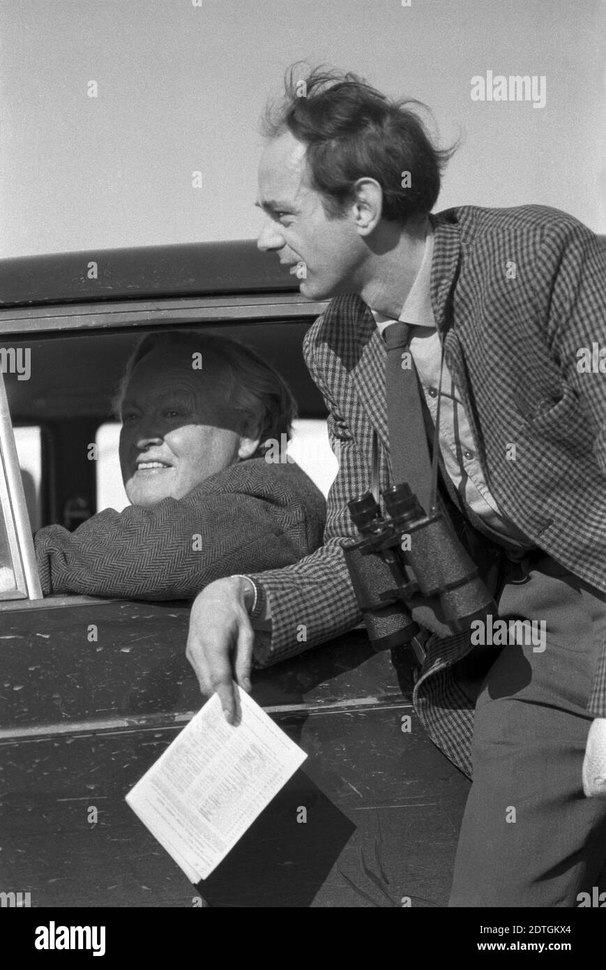 Regno Unito, Inghilterra, Devonshire, Buckfastleigh, 1972. Le gare Point-to-Point si sono svolte a Dean Court sulle paludi Dean, vicino alla A38 tra Plymouth ed Exeter. Spettatori che chiacchierano. Uno ha binocolo intorno al collo e tiene un programma o una scheda di eventi. Foto Stock