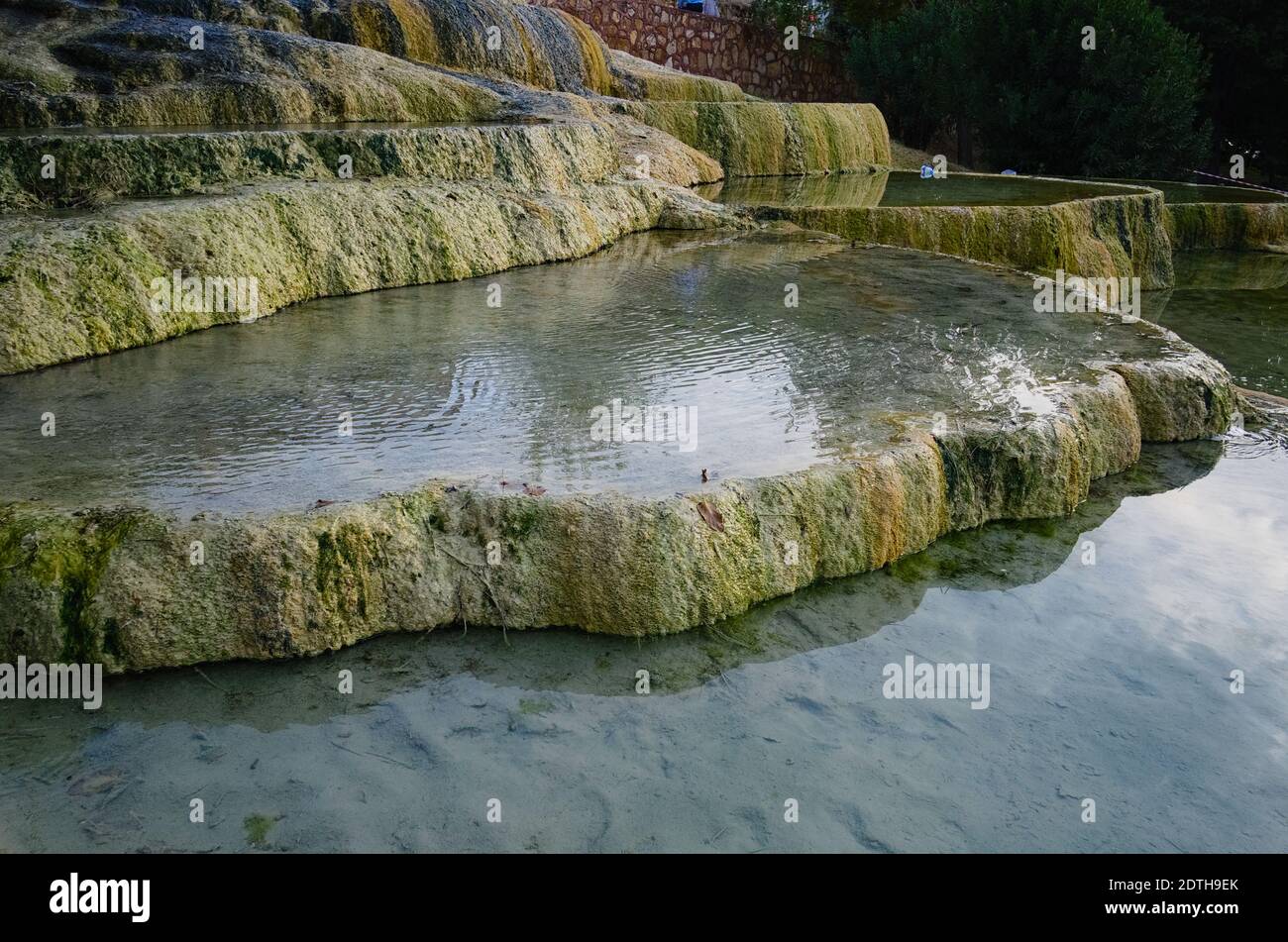 Terrazze in travertino rosso a Karahayit. Bagni di acqua termale trasparenti. Formazione di calcare con acqua calda. Pamukkale / Denizli, Turchia. Foto Stock