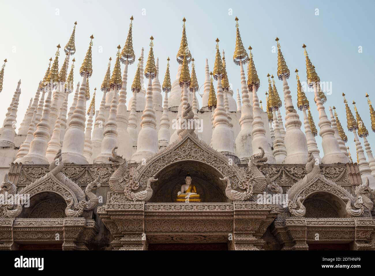 Una statua di Buddha sopra l'ingresso di un tempio buddista in Thailandia. Foto Stock