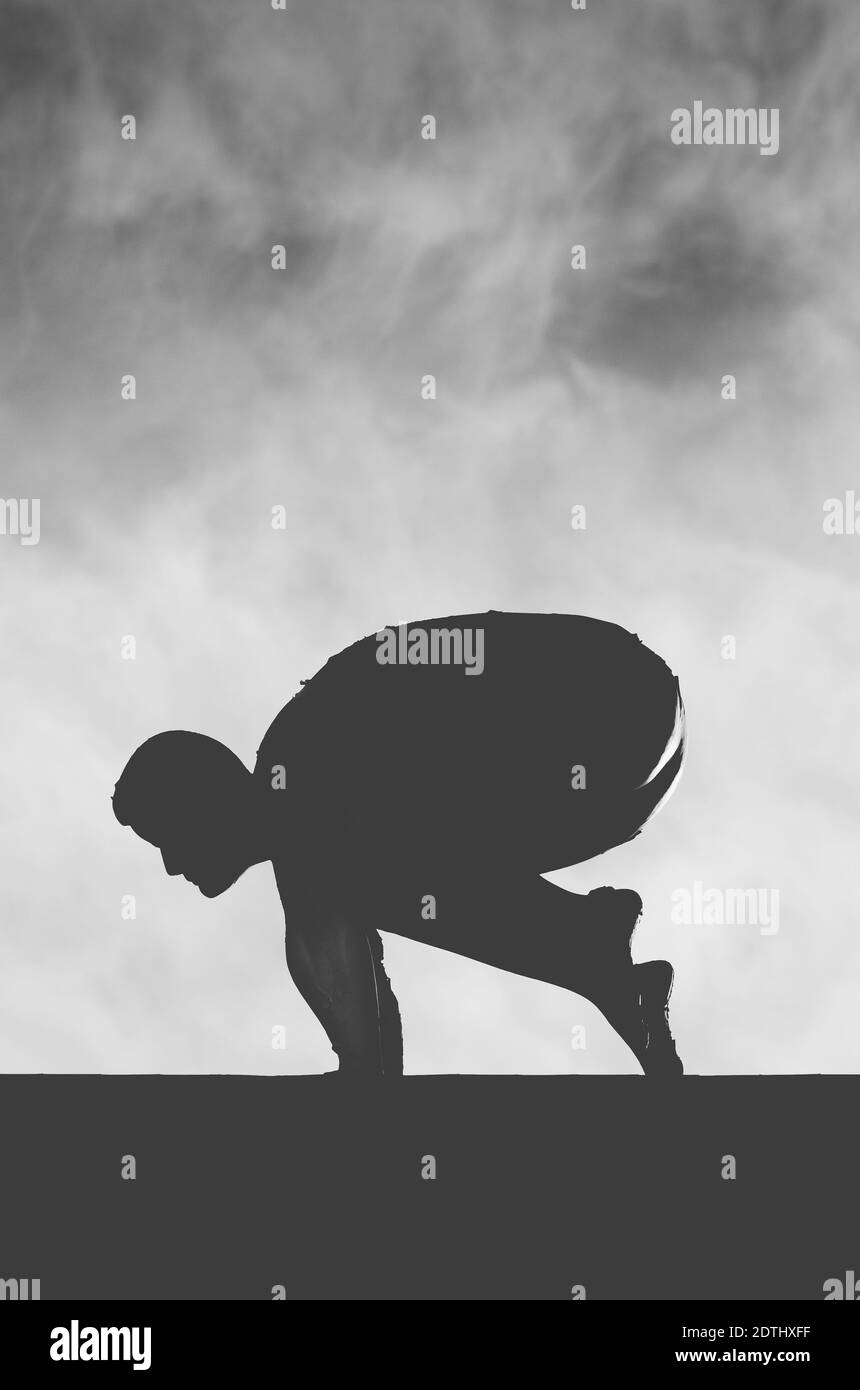 Una foto verticale della silhouette di un uomo che salpava sopra una parete in una posizione di taglio Foto Stock