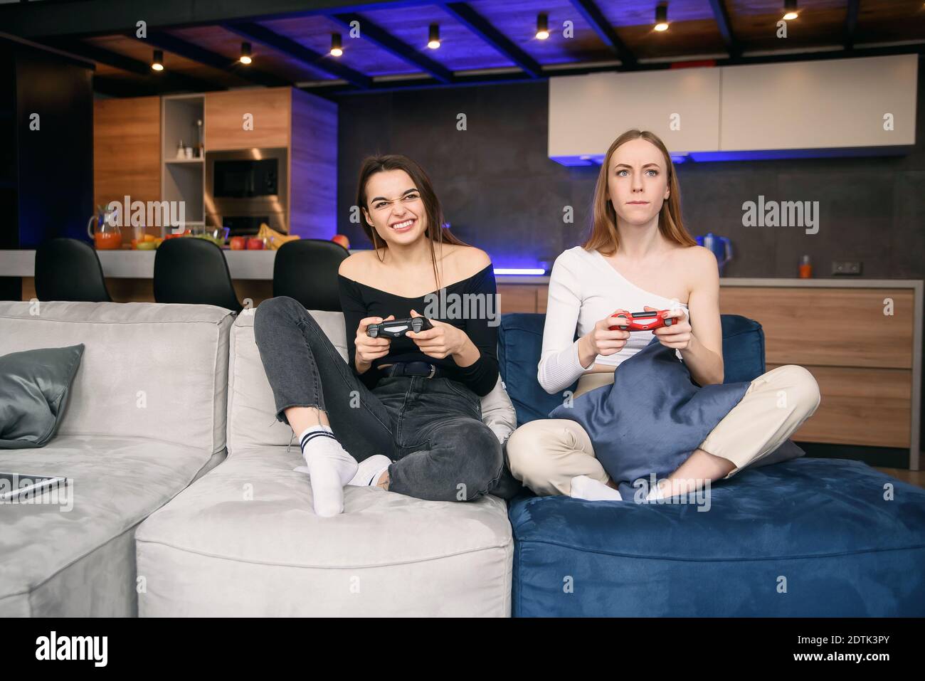 Due migliori girlfriends con una forte eccitazione giocano un interessante videogioco. Amichevole gioco di computer a casa. Foto Stock