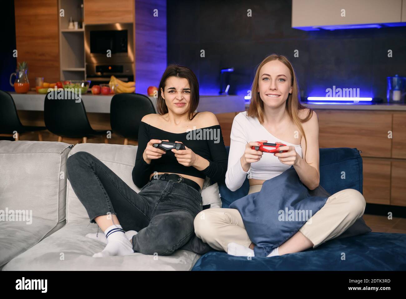 Due migliori girlfriends con una forte eccitazione giocano un interessante videogioco. Amichevole gioco di computer a casa. Foto Stock