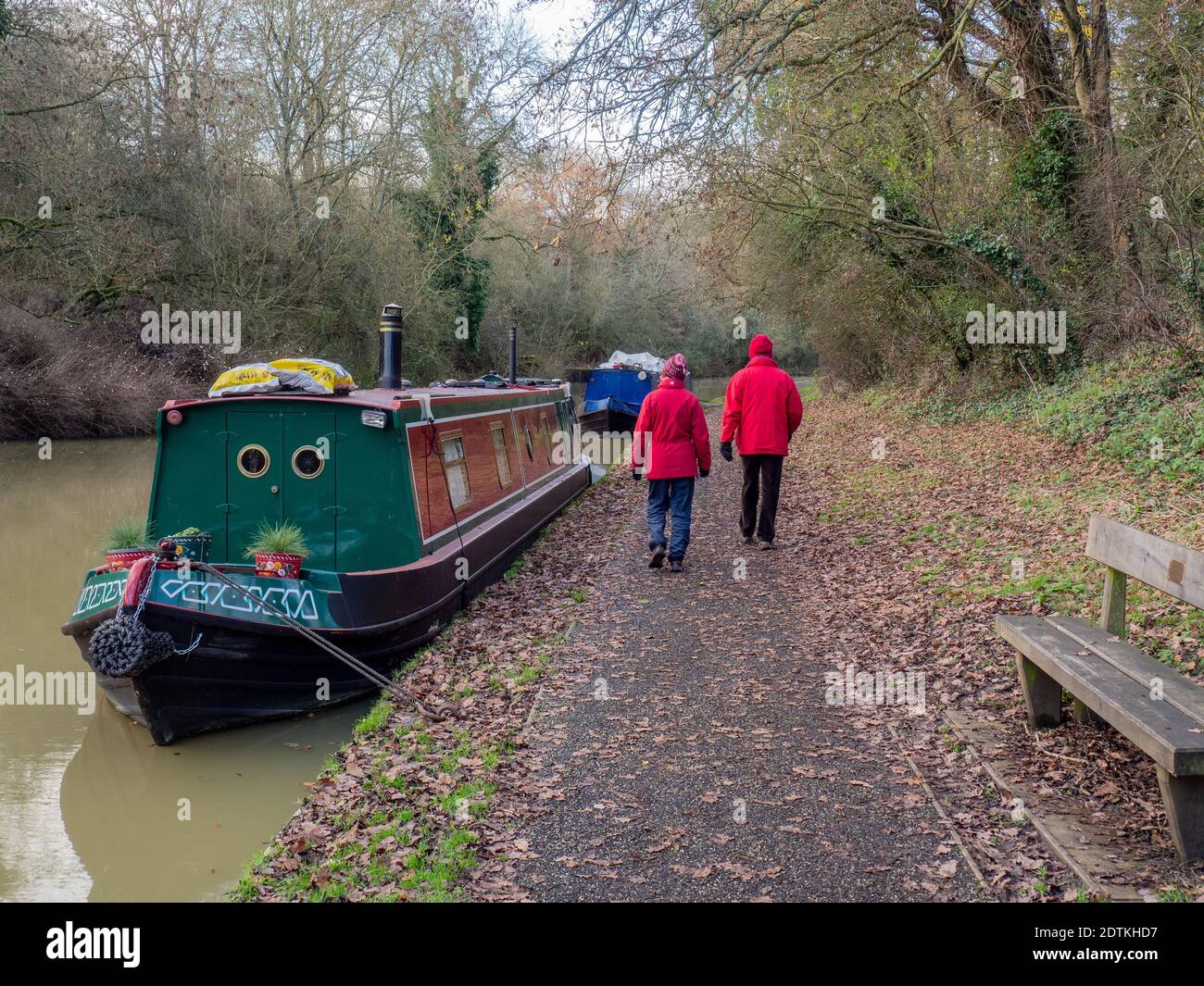 Coppia in cappotti rossi abbinati godendo di una passeggiata invernale vicino al canale a Stoke Bruerne, Northamptonshire, Regno Unito Foto Stock