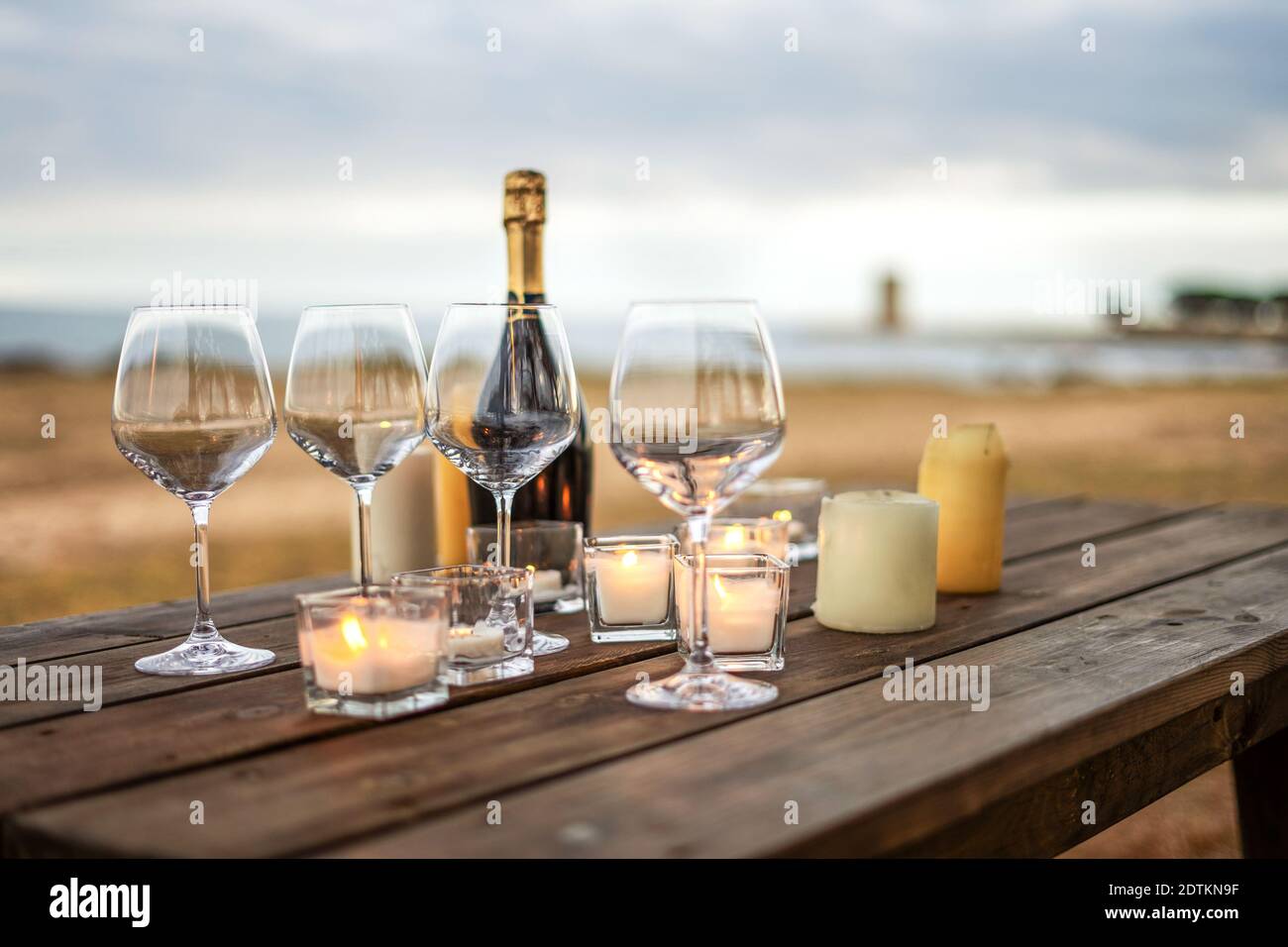 Tutto è pronto per il brindisi di fine anno nelle vacanze invernali al mare - Celebrazione scena con focus selettivo su bicchieri vuoti, bottiglia di champagne chiusa Foto Stock