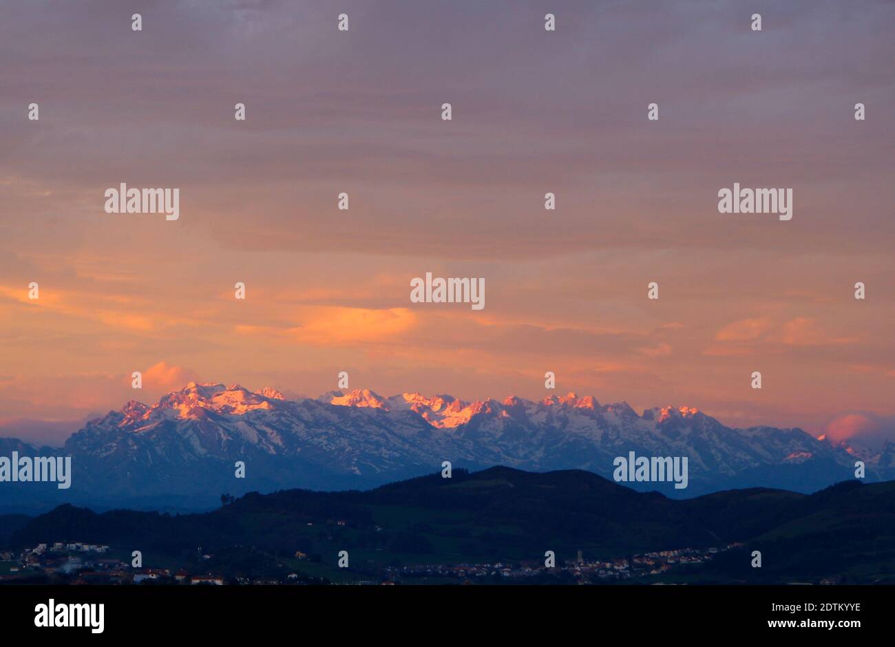 Vista panoramica al mattino presto con luce arancione verso Picos de Europa con neve alta da Santander Cantabria Spagna Foto Stock