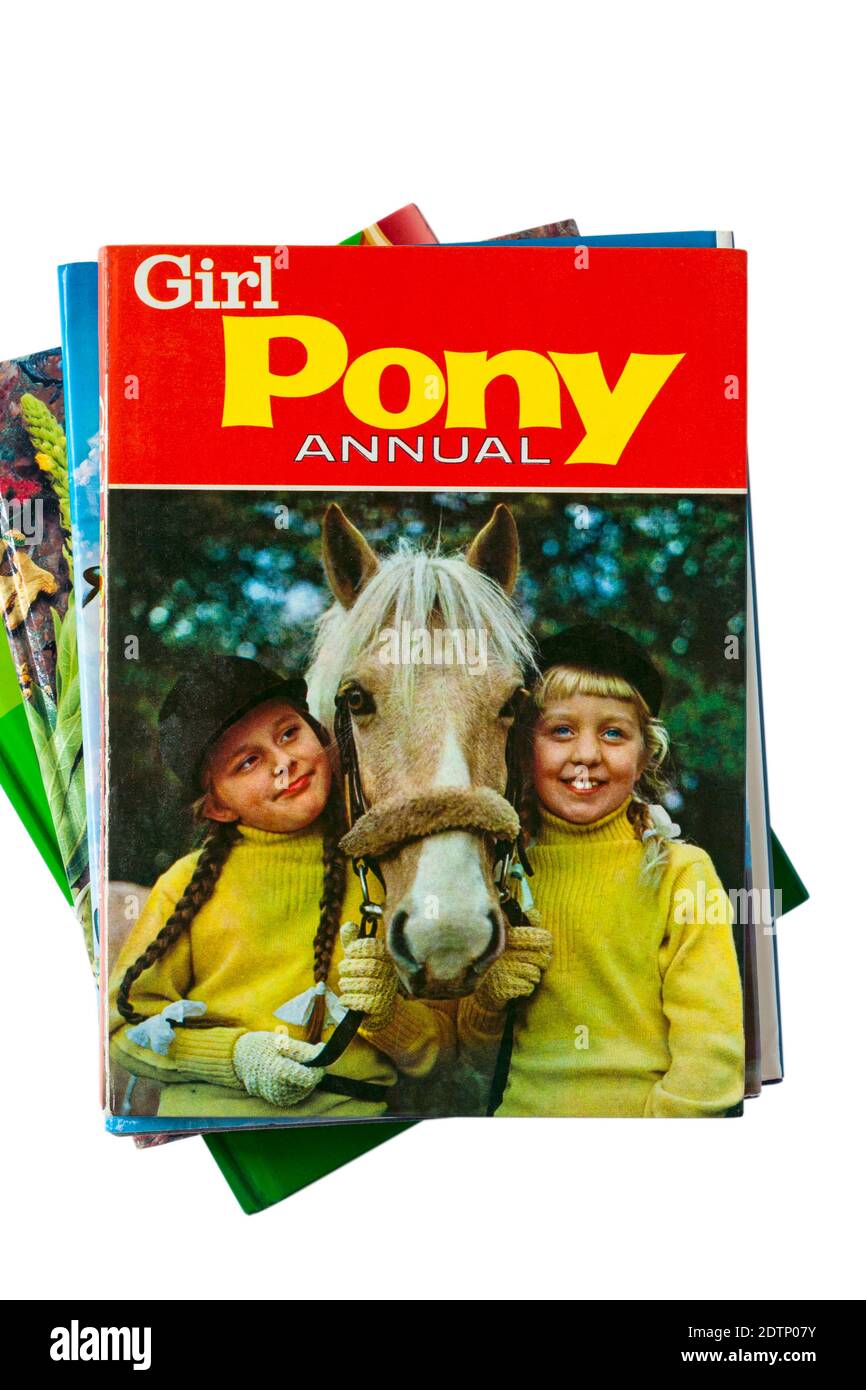 Pila di libri con Girl Pony Annual libro in cima impostare su sfondo bianco Foto Stock