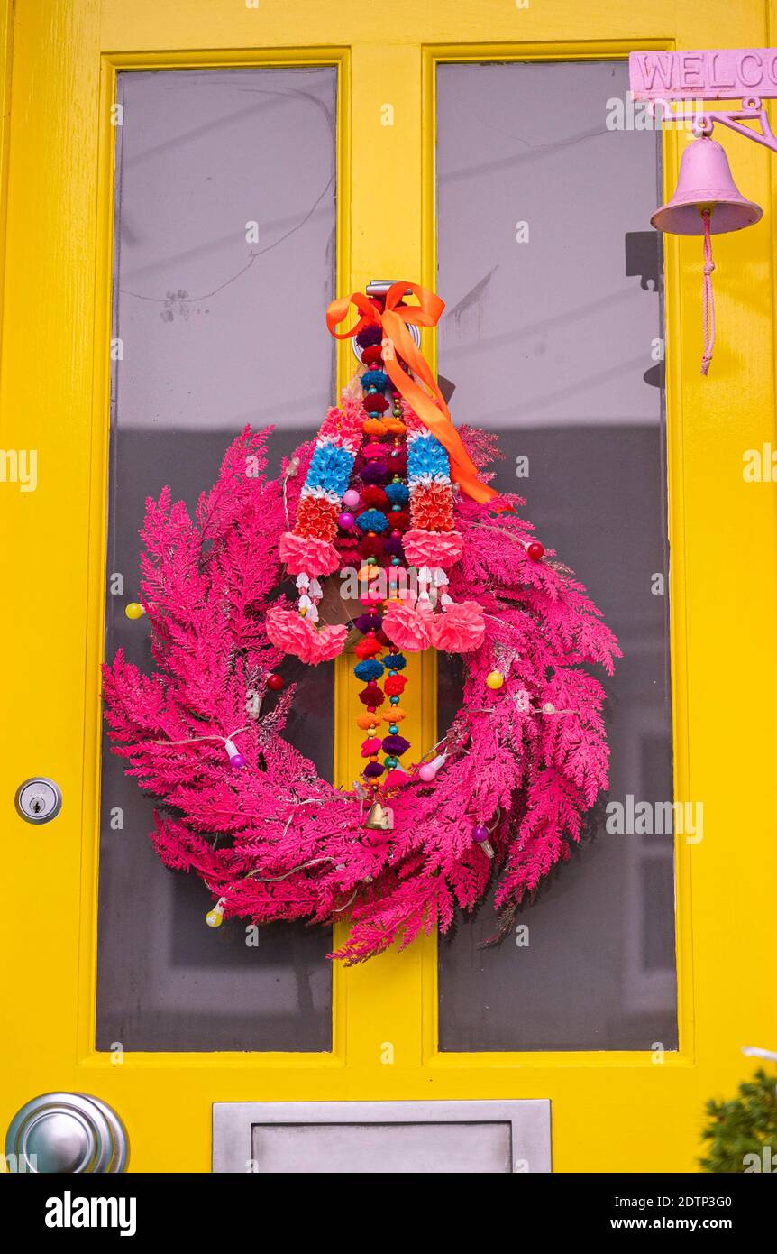 Brighton UK 22 dicembre 2020 - un Natale rosa brillante Decorazione wreath appeso su una porta nel Queens Park Area di Brighton Credit Simon Dack / Alamy Live News Foto Stock