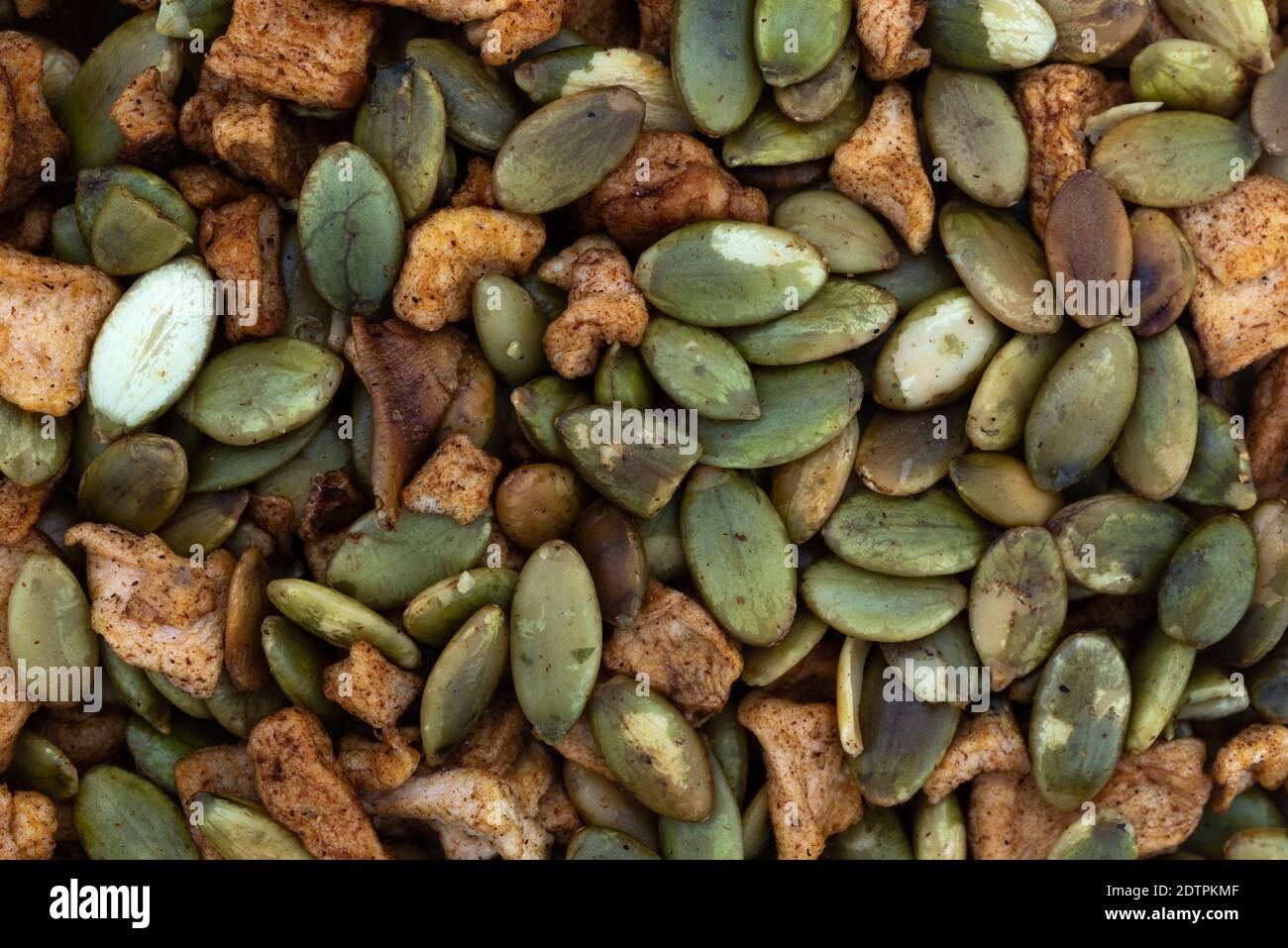 Vista ravvicinata dei semi di zucca arrostiti organici con pezzi di mele disidratati. Foto Stock