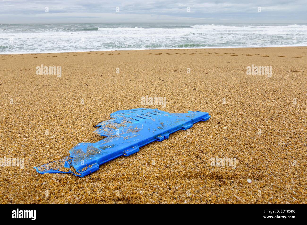 Pezzo di plastica blu sulla spiaggia, concetto di inquinamento Foto Stock