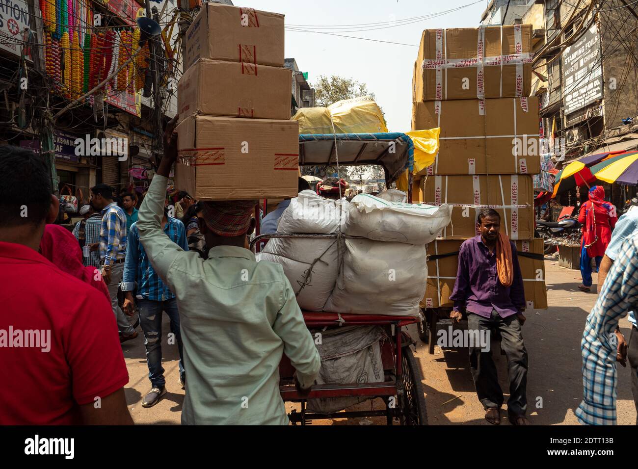 L'uomo porta le scatole di cartone sulla sua testa. Vecchia Delhi - Chandni chowk. India 2019 Foto Stock