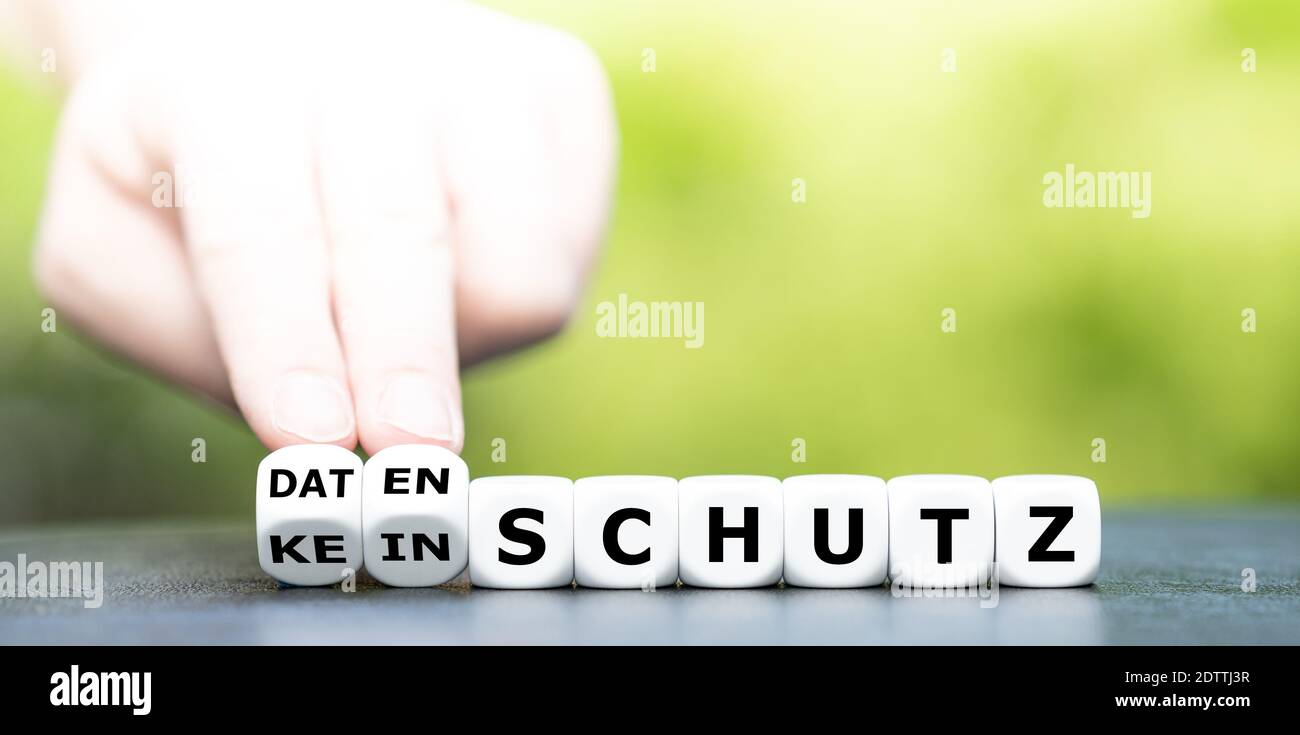 La mano trasforma i dadi e cambia l'espressione tedesca 'kein Schutz' (nessuna protezione) in 'Datenschutz' (privacy dei dati). Foto Stock