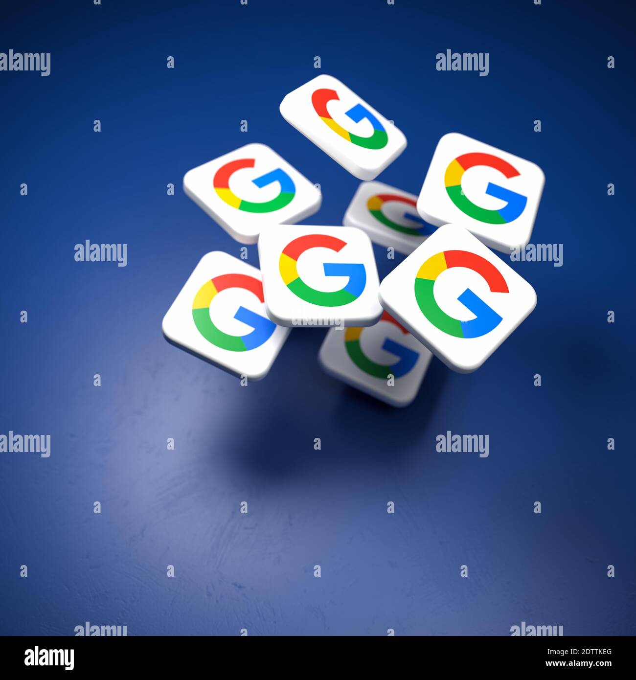 Loghi della società Google / Alphabet che cadono su un tavolo blu. Spazio di copia e messa a fuoco selettiva Foto Stock