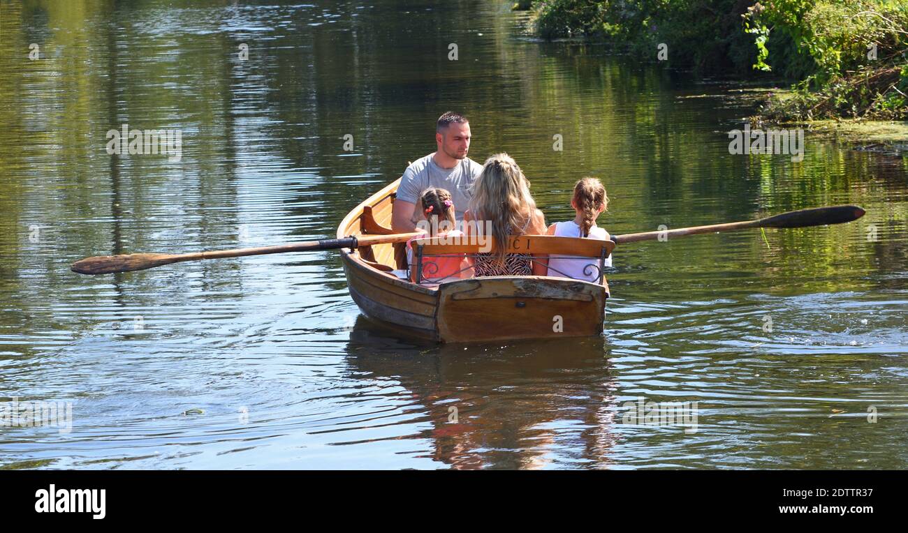 Una coppia con bambini in barca a remi sul fiume Stour vicino Dedham in Essex. Foto Stock