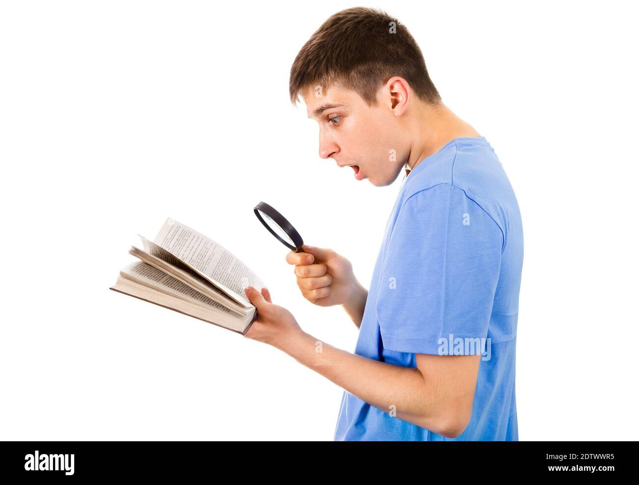 Sorpreso giovane uomo con un libro e lente d'ingrandimento sopra Lo sfondo bianco Foto Stock