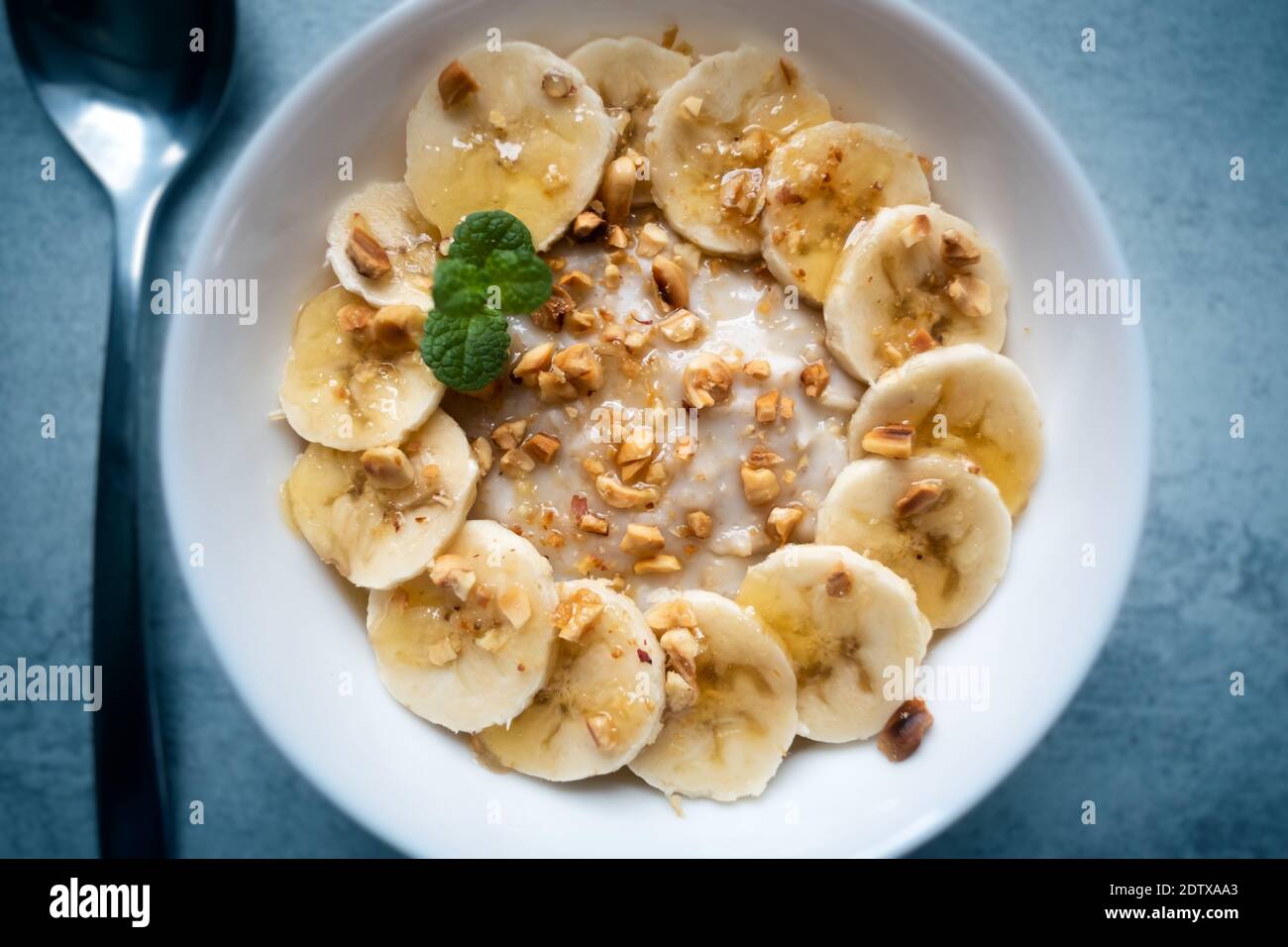 Farinata d'avena con banana, noci e miele in closep bianco della ciotola. Cibo salutare naturale Foto Stock