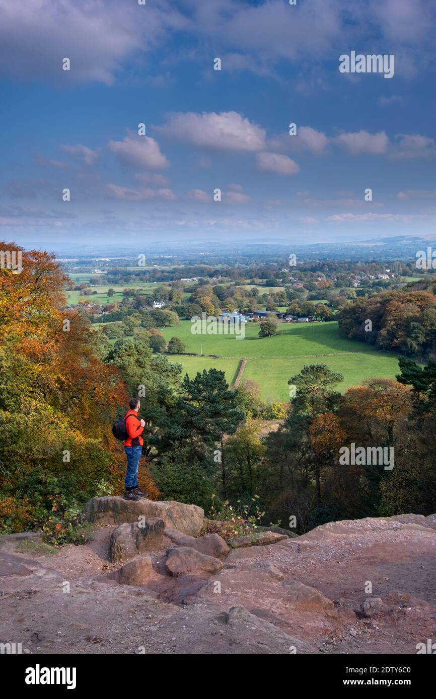 Walker a Stormy Point che si affaccia sulla piana di Cheshire in autunno, Alderley Edge, Cheshire, Inghilterra, Regno Unito Foto Stock
