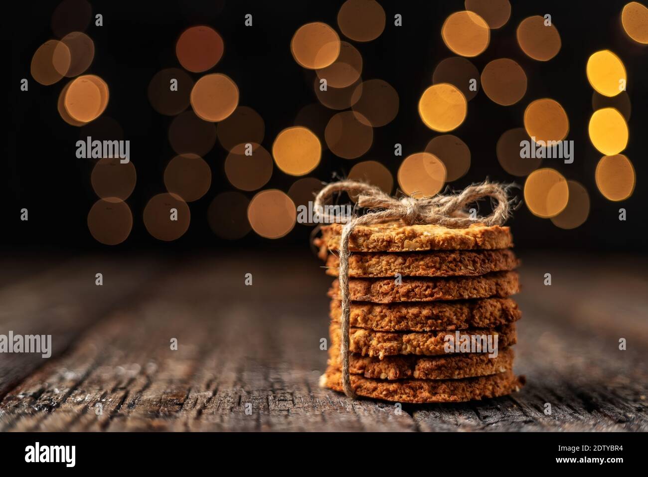 Una pila di biscotti biologici d'avena per Natale, con luci di bokeh incandescenti. Primo piano. Foto Stock