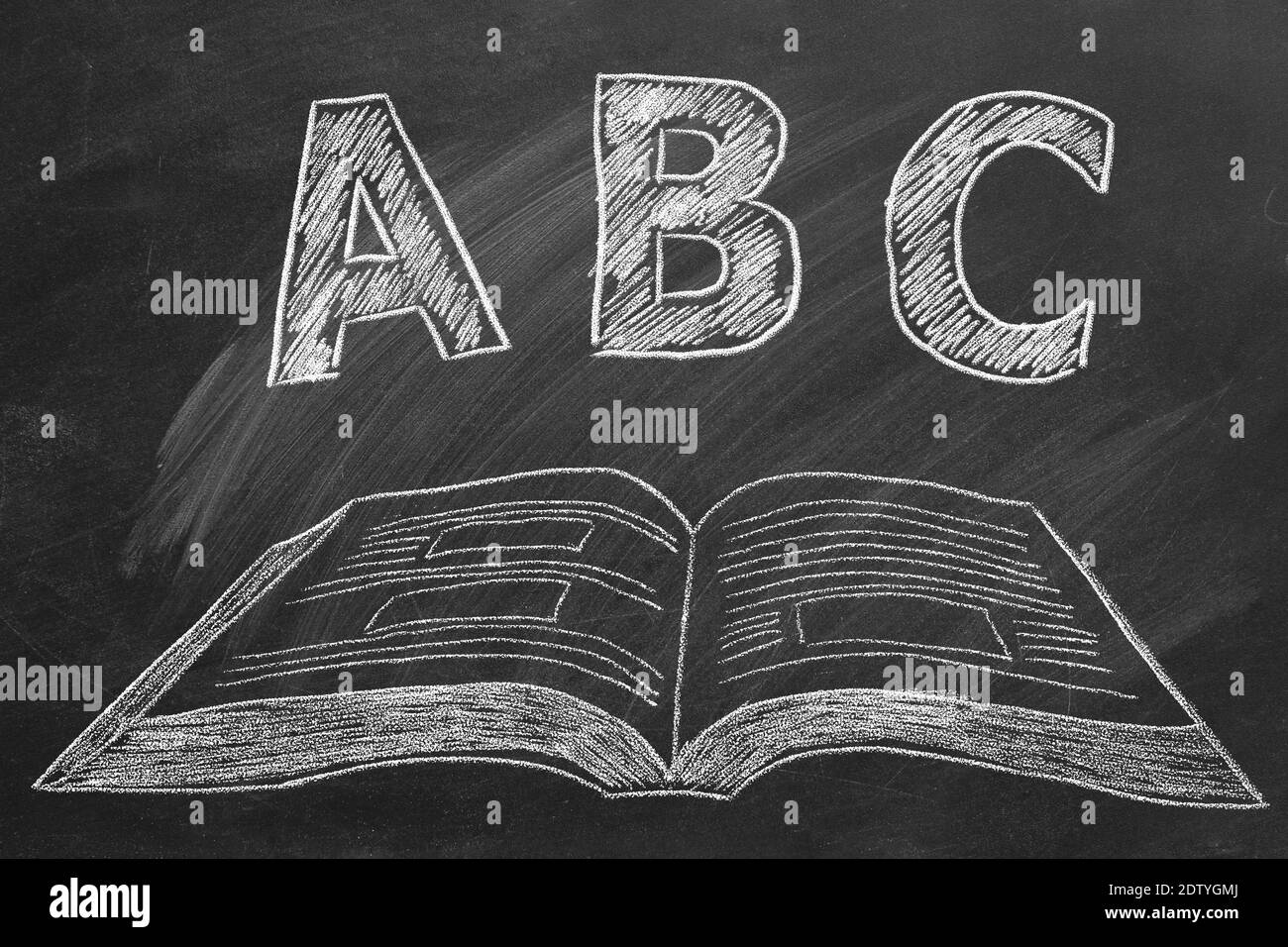 Lettere ABC con libro aperto in gesso sulla lavagna. Scuola elementare. Foto Stock