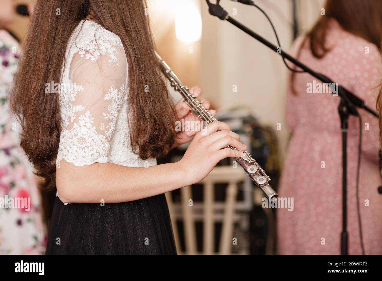 Flutista, giovane ragazza che gioca il flauto, mani, dita su tasti closeup, bambini che giocano trasversale laterale flauto, dettaglio scatto, musica classica, vento Foto Stock