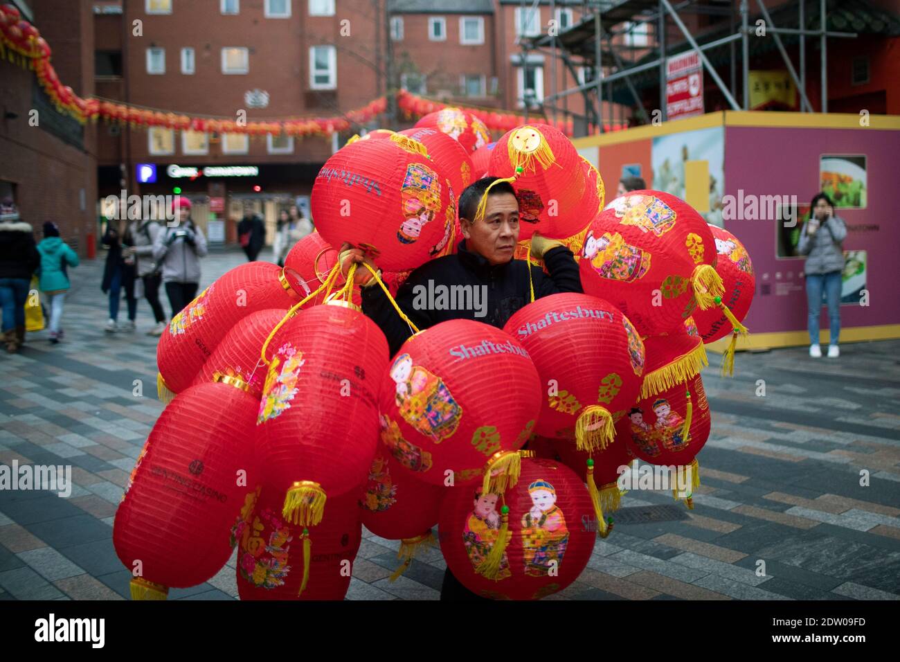Un uomo porta lanterne nella Chinatown di Londra Foto Stock