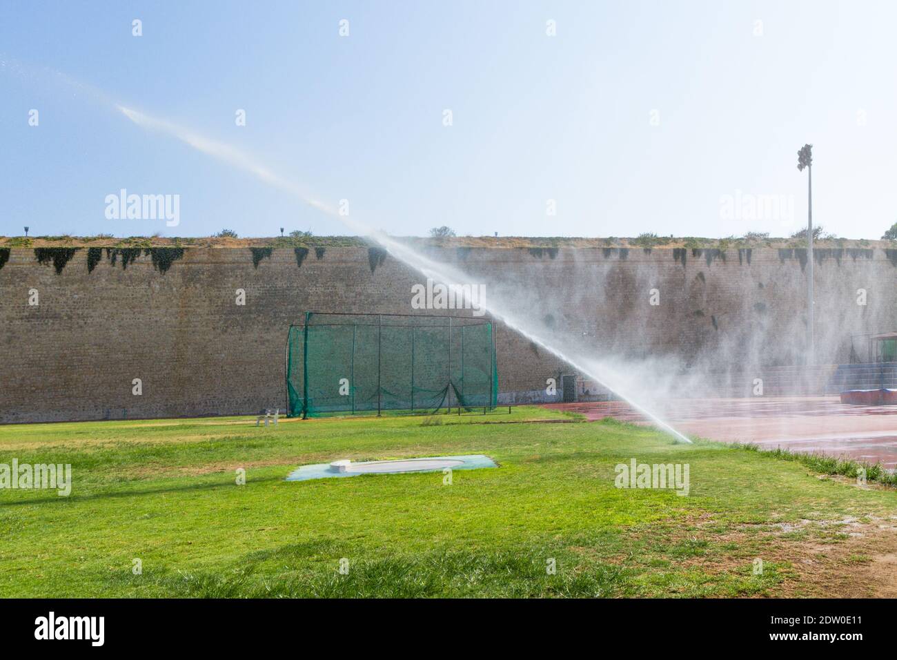 Annaffiare l'erba di uno stadio di allenamento sportivo locale. Foto Stock
