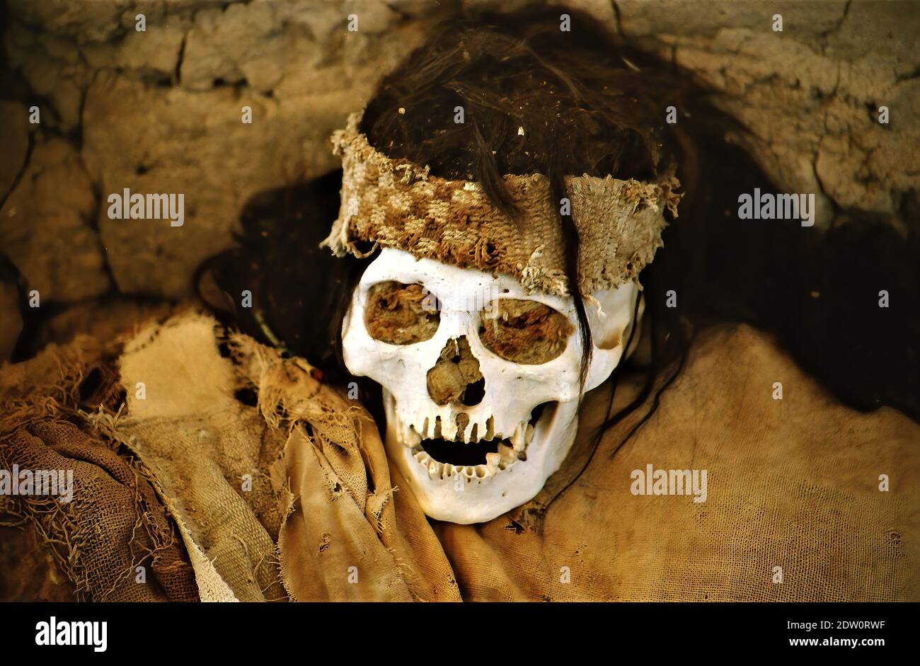 Chauchilla (Nazca), Perù - 9 luglio. 2003: Primo piano del cranio mummia nella tomba del deserto del cimitero peruviano (fuoco sul centro della fascia) Foto Stock