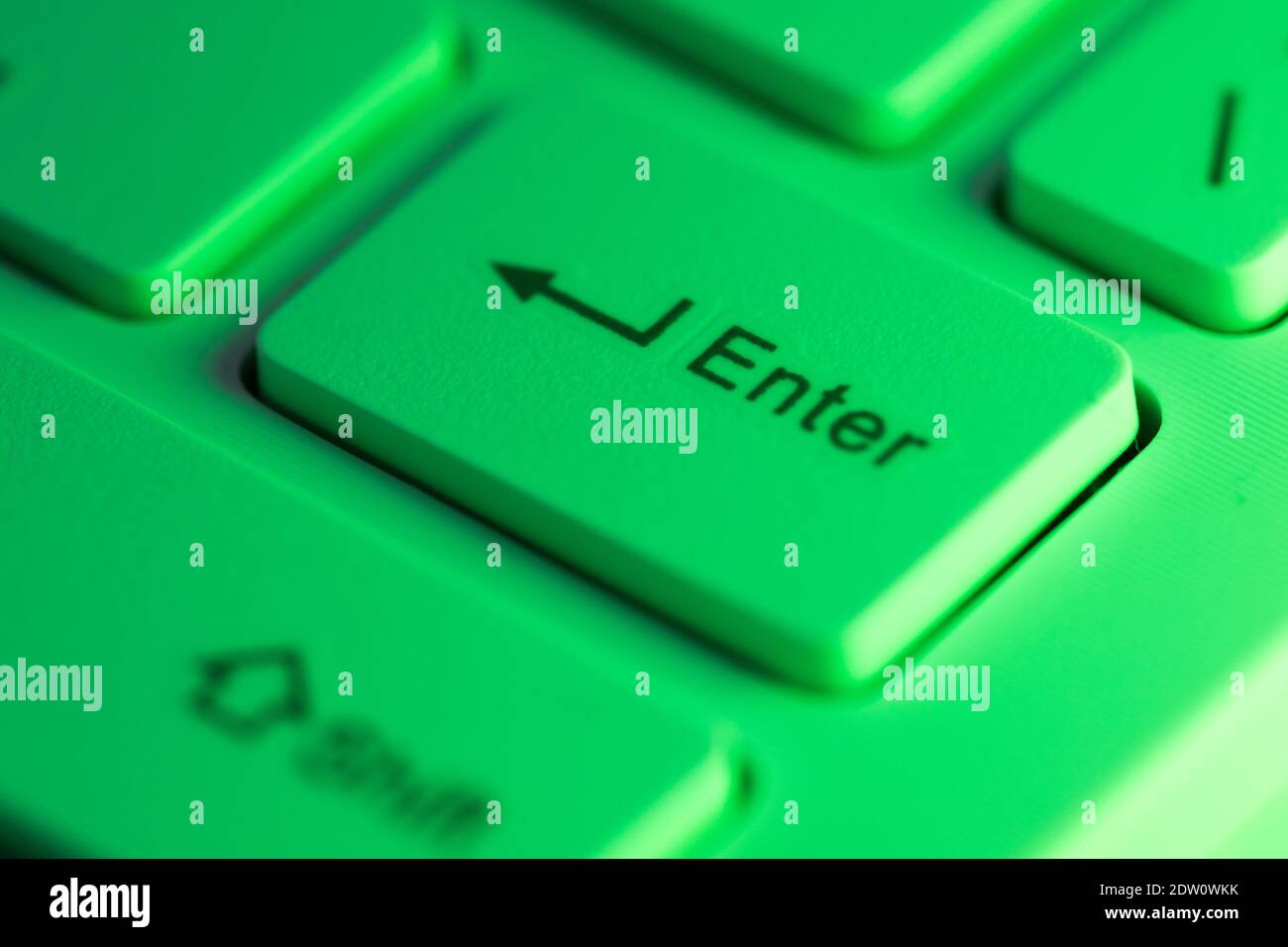Primo piano dettaglio di un tasto di invio verde evidenziato su una tastiera del computer Foto Stock