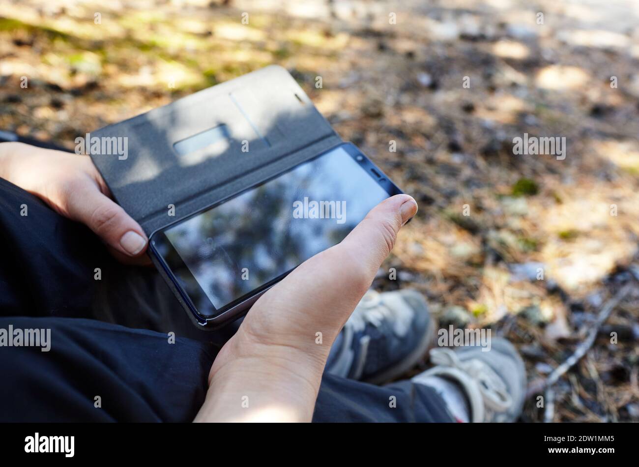 Primo piano delle mani delle donne che tengono il telefono cellulare all'aperto. Spazio di copia per il tuo SMS pubblicitario o contenuti promozionali Foto Stock