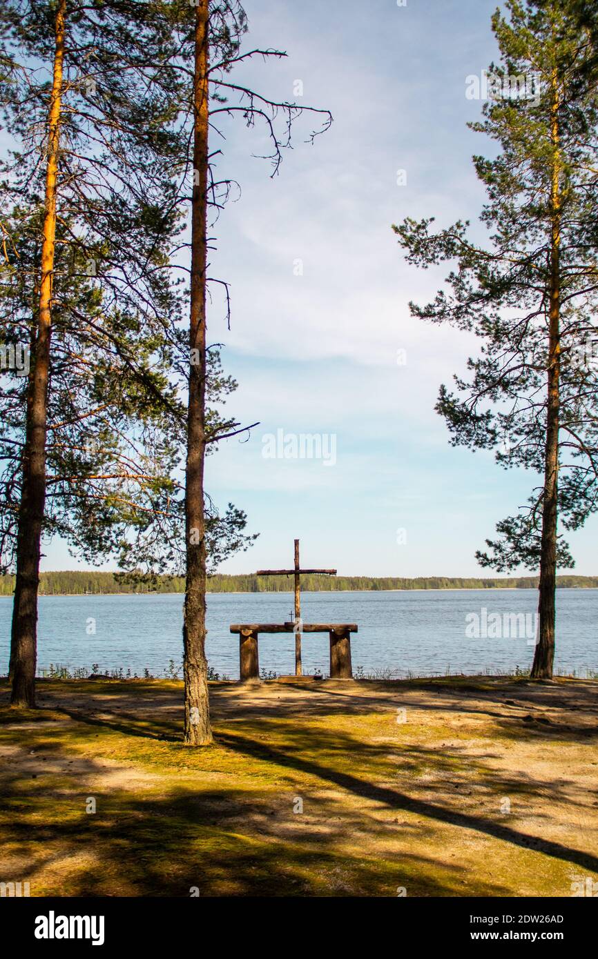 Altare esterno in legno sul bordo del lago e della foresta. Luogo perfetto per celebrare la messa o il matrimonio. Finlandia Foto Stock