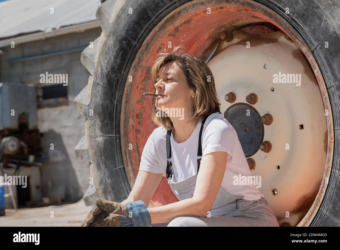 Mature donna meccanica riposo e fumo accanto al camion Foto Stock