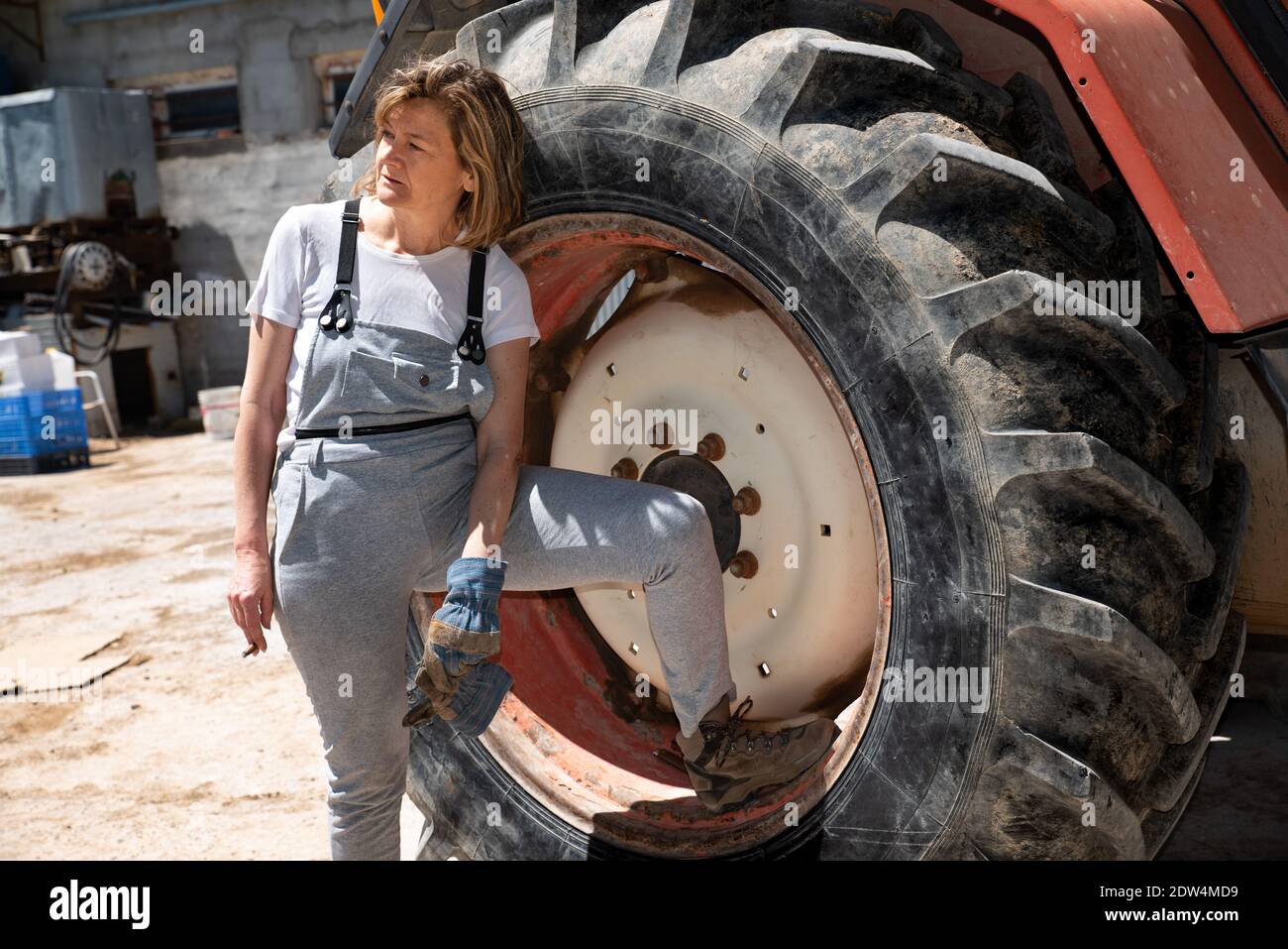 Mature donna meccanica riposo e fumo accanto al camion Foto Stock