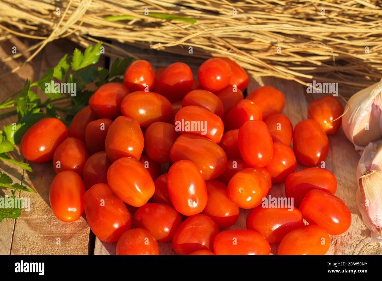 pomodori maturi con aglio e fondo rustico Foto Stock