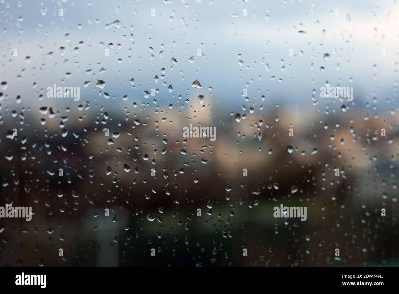 Gouttes de pluie sur la vitre dans une ville métropolitaine française Foto Stock