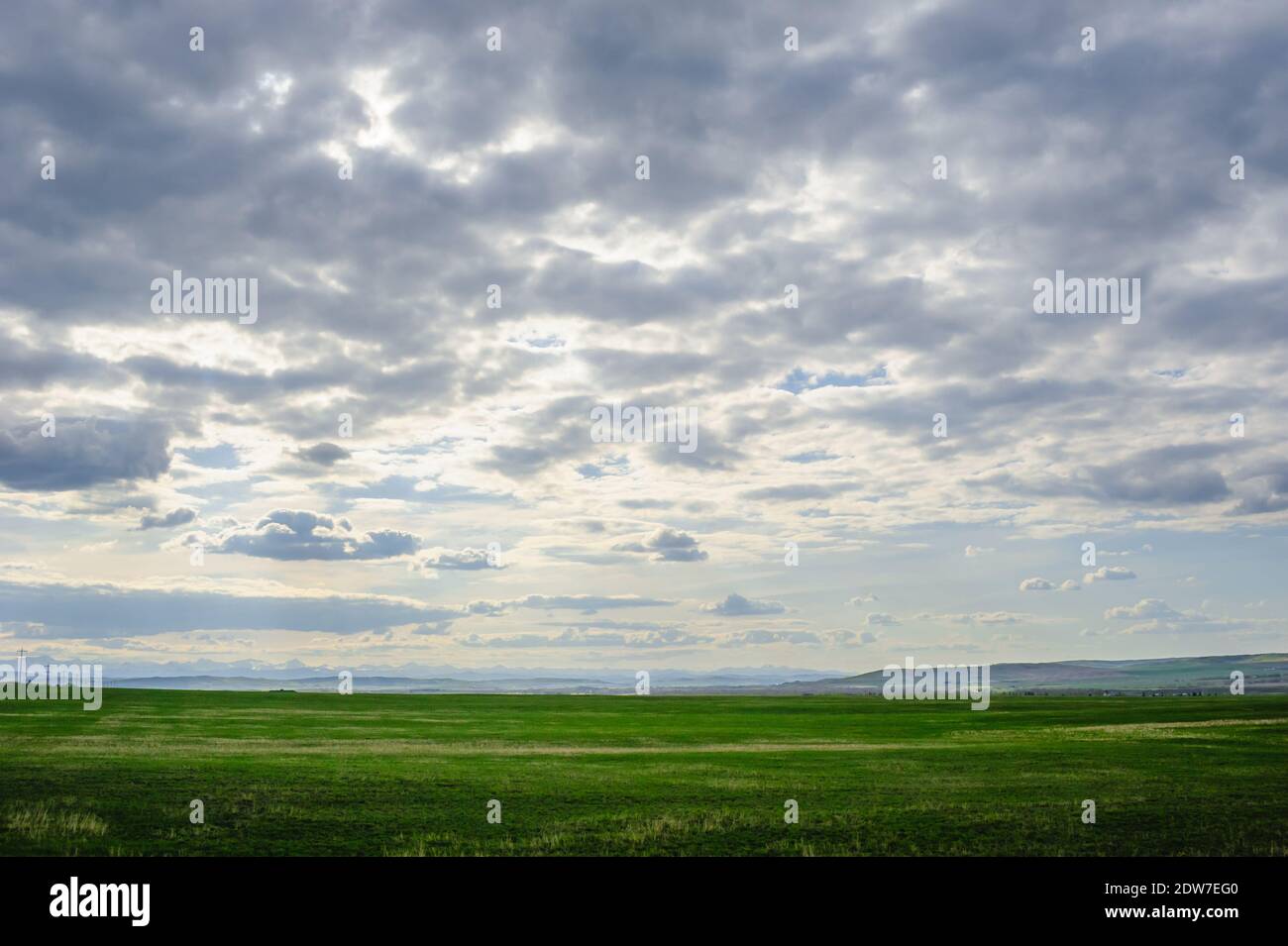 Paesaggio Prairie con montagne in lontananza sotto le nuvole basse, in Alberta, Canada. Foto Stock