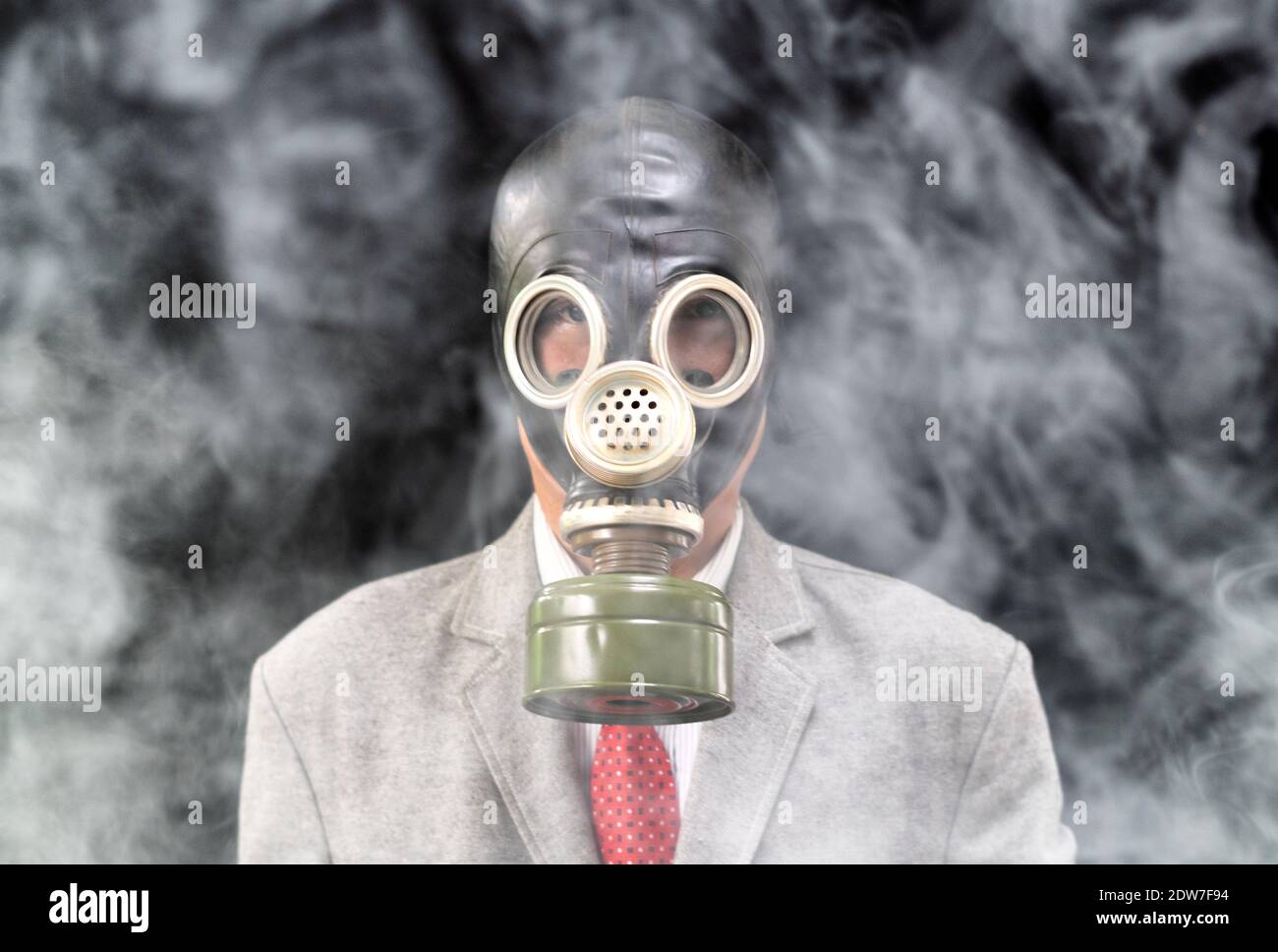 Ritratto di uomo d'affari che indossa una maschera a gas in piedi tra fumo  e sfondo nero Foto stock - Alamy