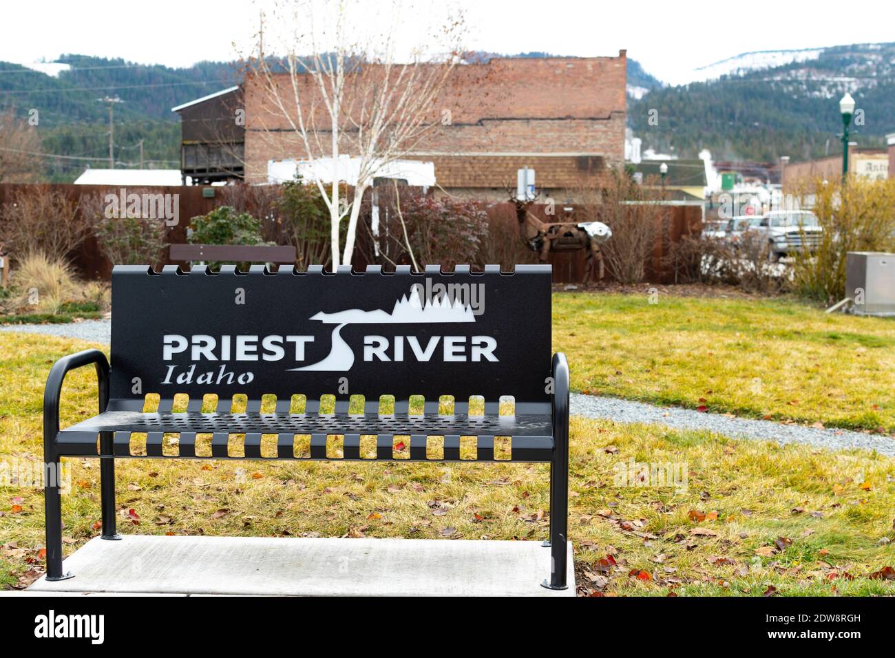Il cartello di benvenuto e il logo Priest River Idaho sul retro di una panchina in un piccolo parco nel fiume Priest, Idaho USA. Foto Stock