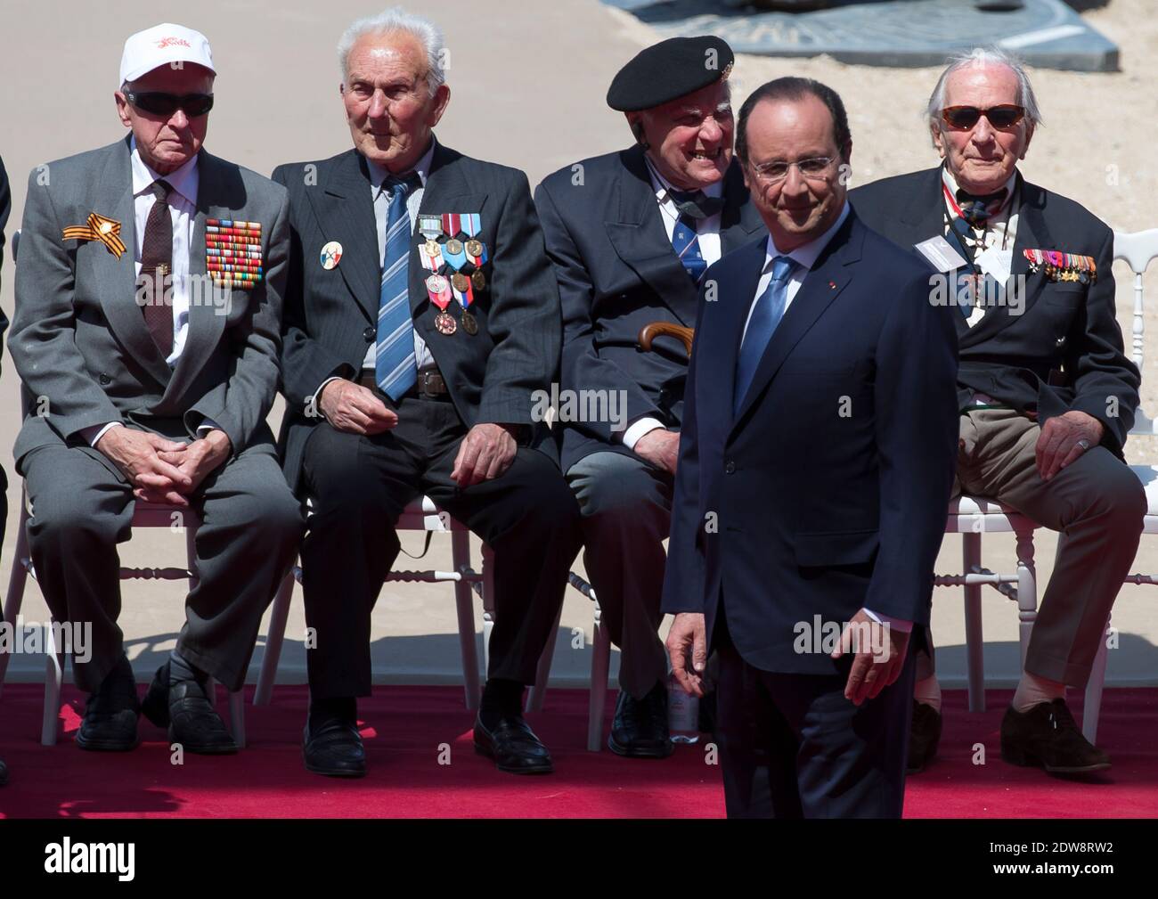 Il presidente francese Francois Hollande attende l'arrivo di dignitari stranieri mentre i veterani della seconda guerra mondiale si siedono sullo sfondo durante una cerimonia internazionale che celebra il 70° anniversario degli sbarchi alleati in D-Day a Sword Beach a Ouistreham, in Normandia, Francia, il 06 giugno 2014. Più di 75,000 truppe canadesi e altre truppe del Commonwealth sbarcati sulle spiagge della Normandia il 06 giugno 1944, insieme agli Stati Uniti e ai francesi liberi, in un'invasione alleata di oltre 130,000. Altre 7,900 truppe britanniche sono state sbarcate da Air. L'invasione ha stabilito un secondo fronte cruciale nella Liberazione di e Foto Stock