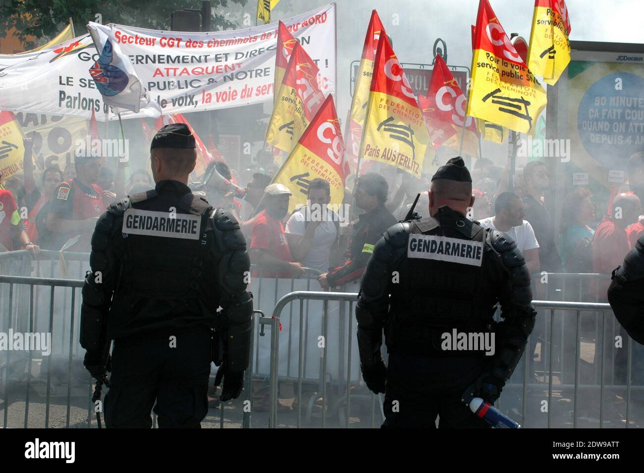 I gas lacrimogeni delle forze di polizia contro i manifestanti che si sono afferri sulle barriere di controllo della folla durante una dimostrazione da parte dei dipendenti della compagnia ferroviaria statale francese SNCF presso il Ministero dei Trasporti a Parigi, Francia, il 12 giugno 2014; il secondo giorno di uno sciopero a livello nazionale per protestare contro un progetto di riforma ferroviaria del governo. Uno sciopero ferroviario nazionale convocato dai sindacati per protestare contro una proposta di riforma ferroviaria volta a contenere il crescente debito del settore, iniziata la sera di giugno 10, è stato rinnovato una seconda volta per altre 24 ore il 12 giugno. Foto di Alain Apaydin/ABACAPRESS.COM Foto Stock