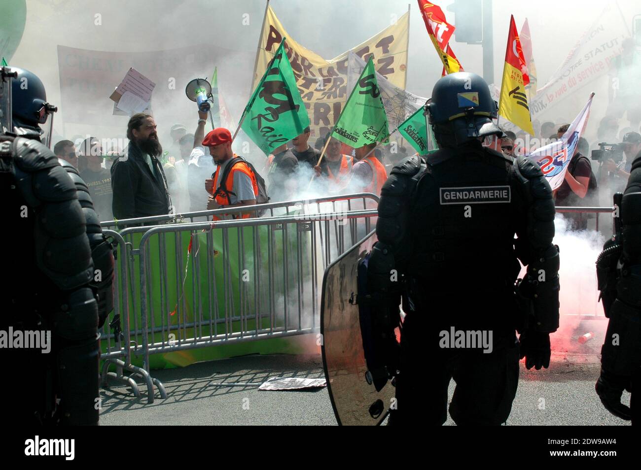 I gas lacrimogeni delle forze di polizia contro i manifestanti che si sono afferri sulle barriere di controllo della folla durante una dimostrazione da parte dei dipendenti della compagnia ferroviaria statale francese SNCF presso il Ministero dei Trasporti a Parigi, Francia, il 12 giugno 2014; il secondo giorno di uno sciopero a livello nazionale per protestare contro un progetto di riforma ferroviaria del governo. Uno sciopero ferroviario nazionale convocato dai sindacati per protestare contro una proposta di riforma ferroviaria volta a contenere il crescente debito del settore, iniziata la sera di giugno 10, è stato rinnovato una seconda volta per altre 24 ore il 12 giugno. Foto di Alain Apaydin/ABACAPRESS.COM Foto Stock