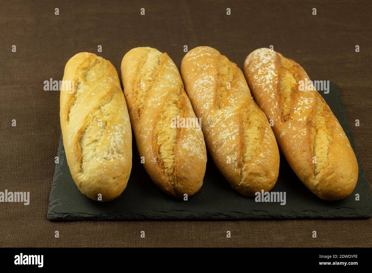 Panini e panini appena sfornati per cani caldi. Panini deliziosi e croccanti. Pane sul tavolo Foto Stock