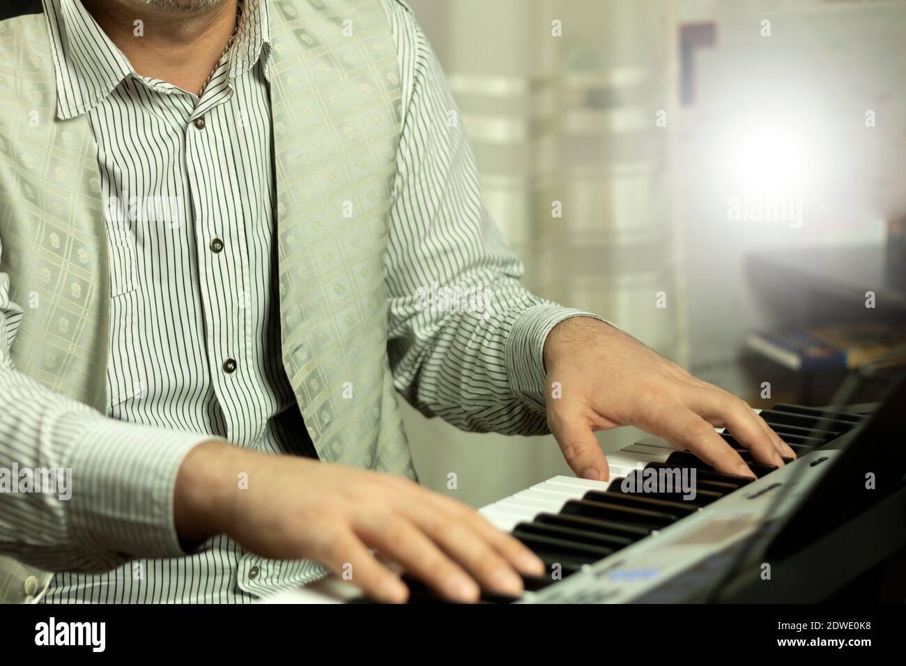 Le mani del musicista sulla tastiera del pianoforte durante la riproduzione. Un uomo suona un sintetizzatore a casa. Sfondo con posizione per il testo Foto Stock