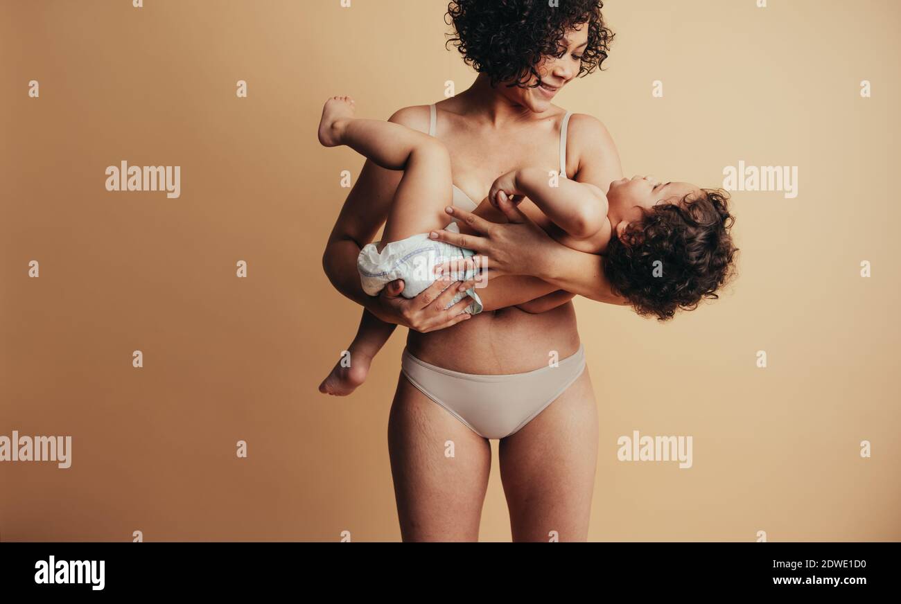 Donna che porta il suo bambino tra le braccia. Madre e bambino amorevoli. Foto Stock