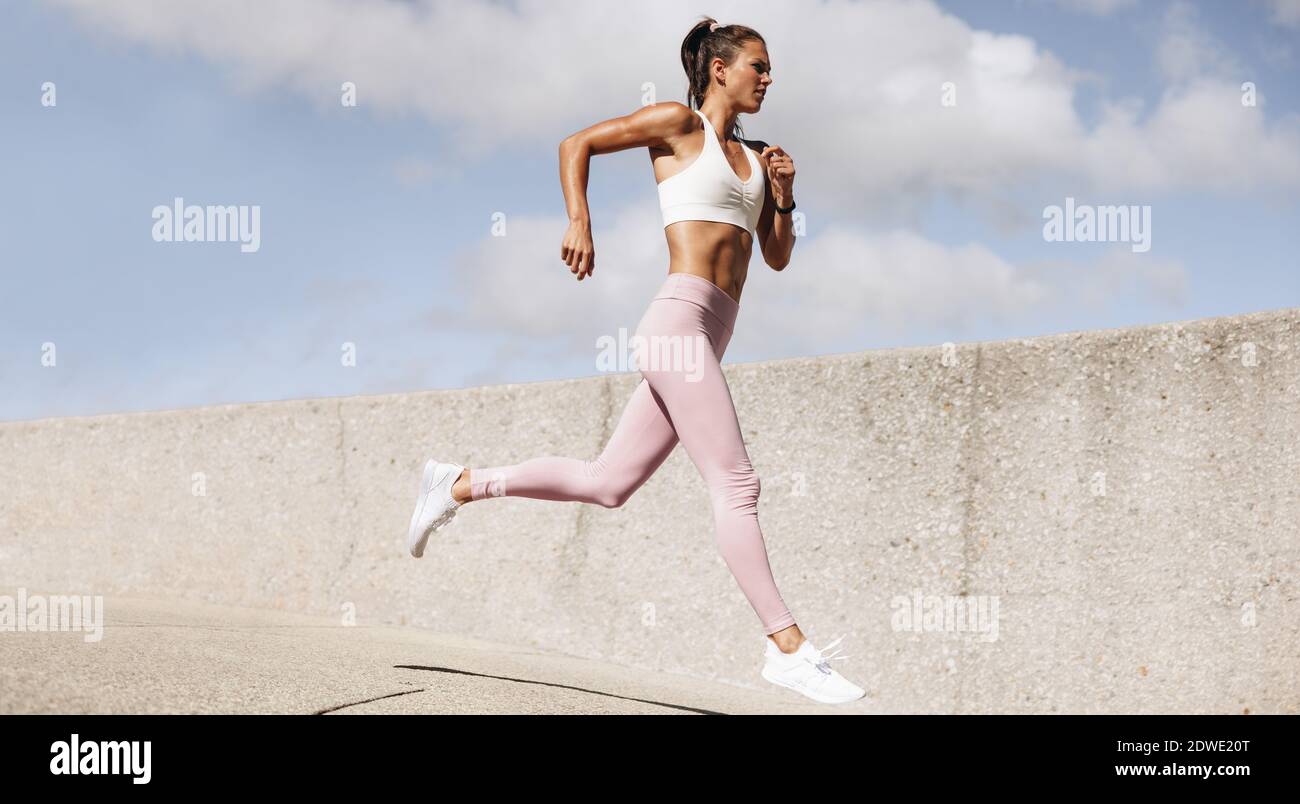Donna sana al mattino run. Atleta femminile in abbigliamento fitness facendo esercizio in corsa. Foto Stock