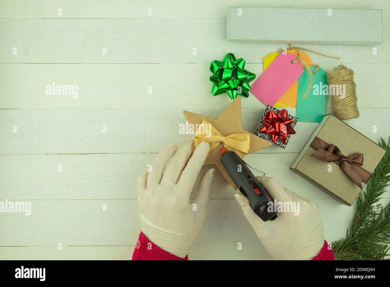 La ragazza sta imballando i regali nell'imballaggio di festa. Fare il regalo e l'imballaggio come idea di affari. Affari domestici. Guadagnare da hobby e artigianato Foto Stock