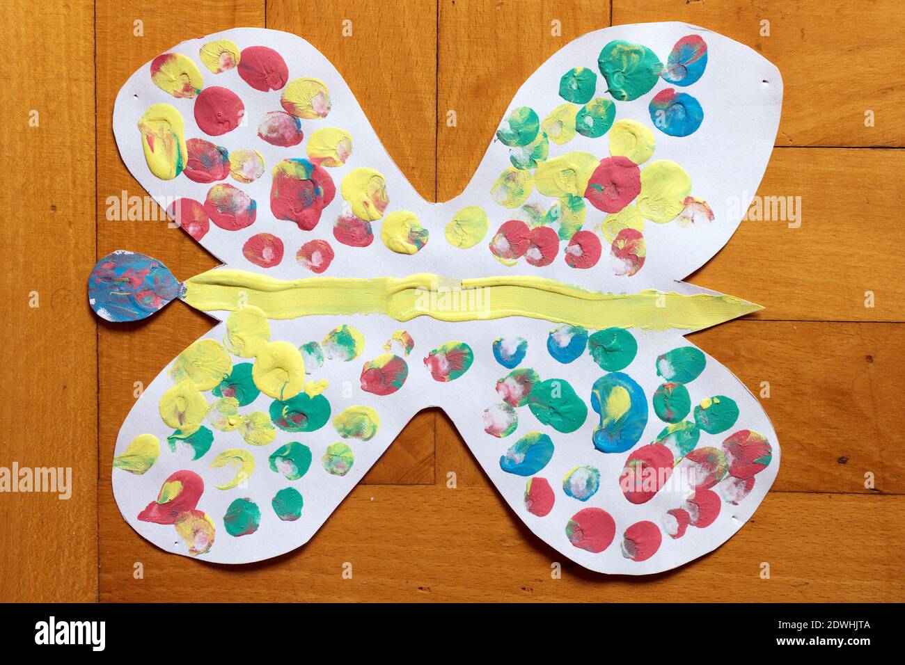 Disegno di bambino di sette anni, farfalla colorata di carta su pavimento di legno. Foto Stock
