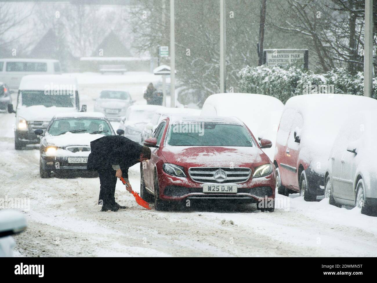 26/02/2018. Meteo: Bestia da est. Un automobilista cerca di sgombrare la neve da sotto la sua auto a Dalkeith. PIC Ian Rutherford Foto Stock