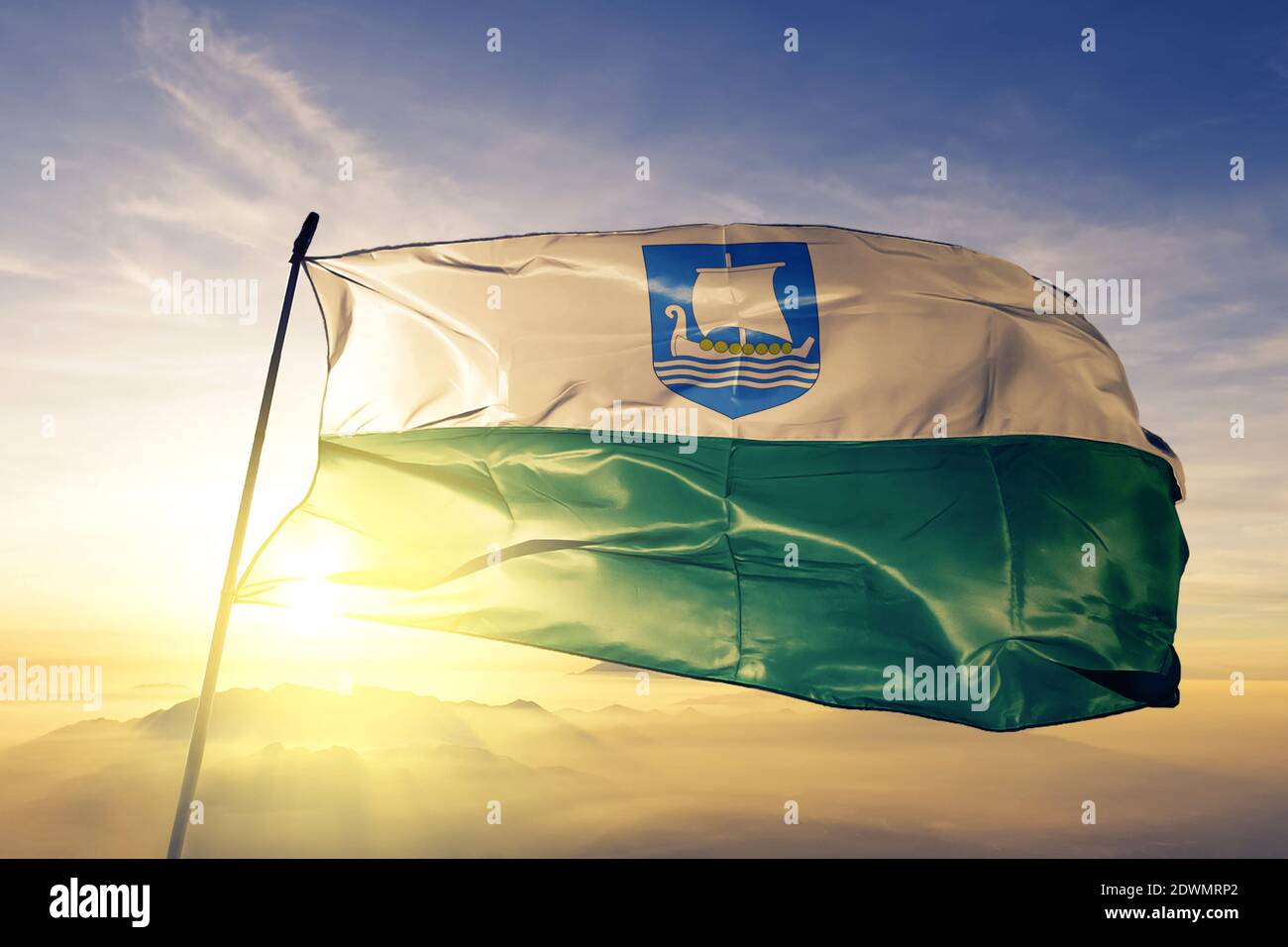 Bandiera della contea di Saare in Estonia che sventola sull'alba nebbia Foto Stock