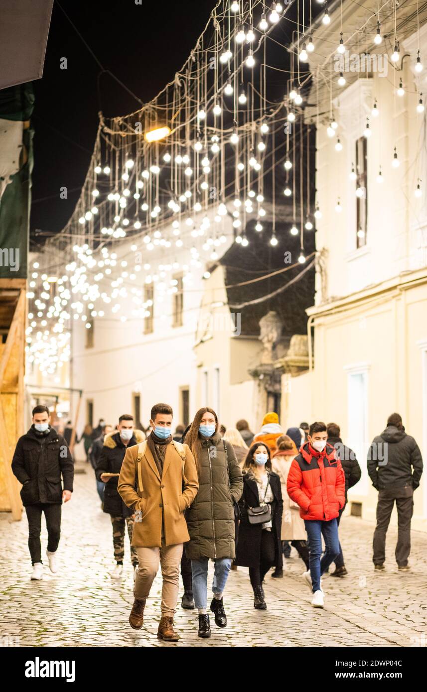 CLUJ-NAPOCA, ROMANIA - 22 DICEMBRE 2020: Persone che indossano la maschera sulla strada luci di Natale Foto Stock