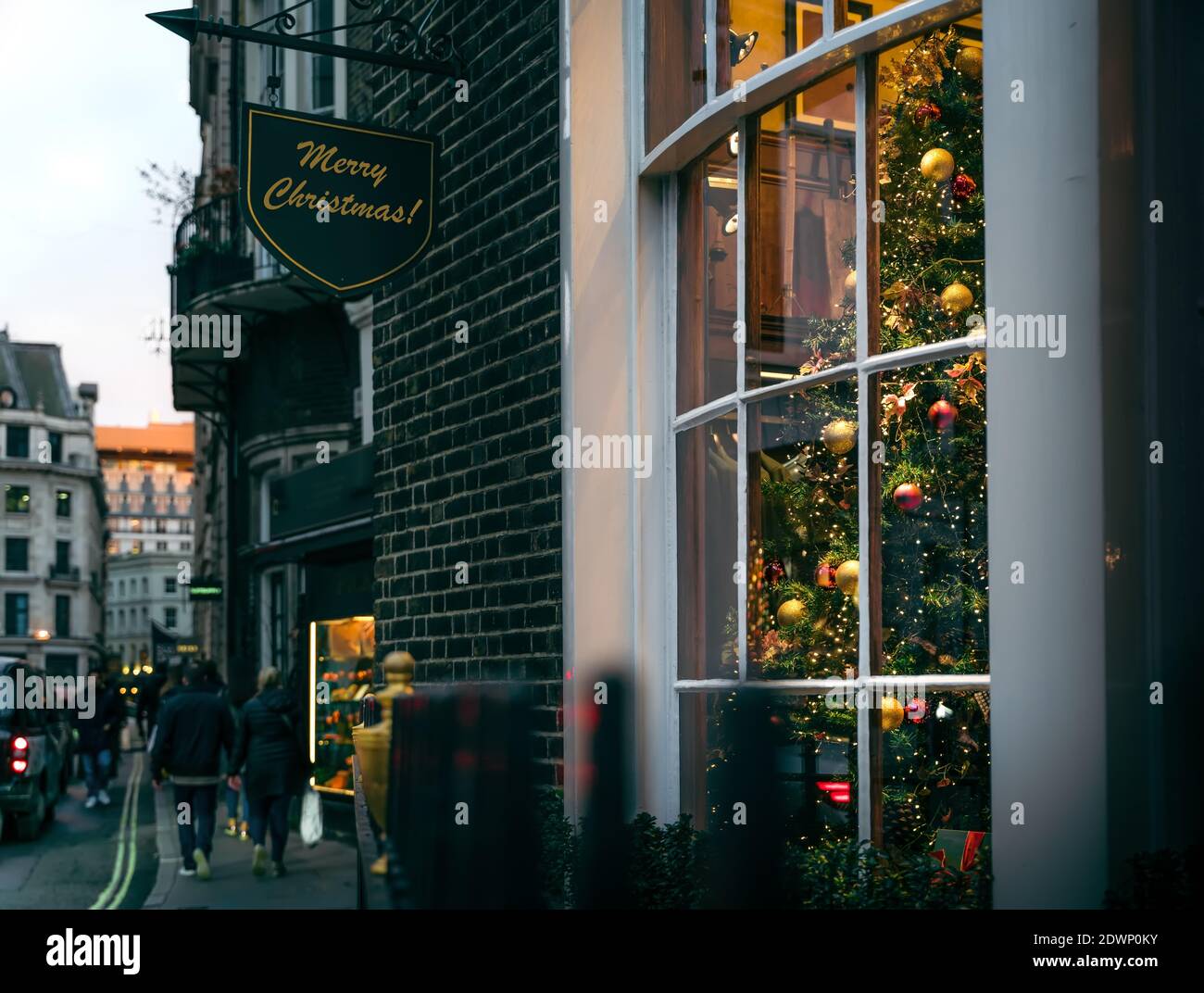 Vista sull'albero di Natale tradizionale nella camera accogliente dietro la finestra con la scena di British Street al tramonto, Londra, Regno Unito Foto Stock